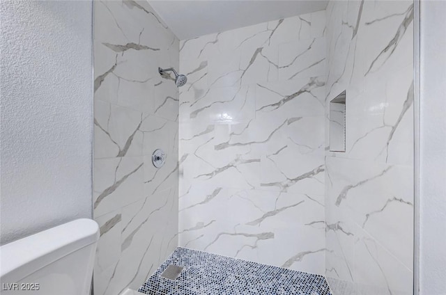 full bath featuring toilet and a marble finish shower