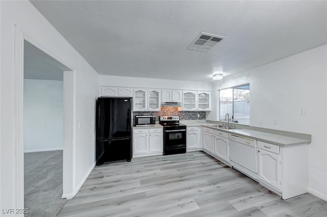 kitchen with range with electric cooktop, white cabinets, dishwasher, glass insert cabinets, and freestanding refrigerator