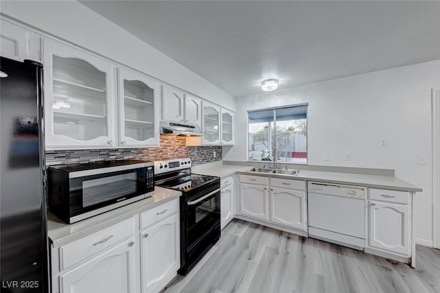 kitchen featuring electric range, dishwasher, stainless steel microwave, light countertops, and black fridge