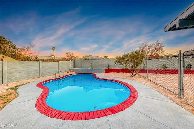 pool at dusk featuring a fenced in pool and a fenced backyard