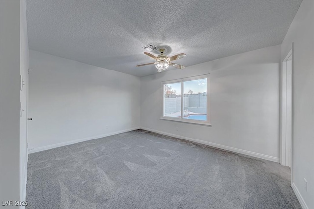 unfurnished room featuring light colored carpet, visible vents, ceiling fan, a textured ceiling, and baseboards