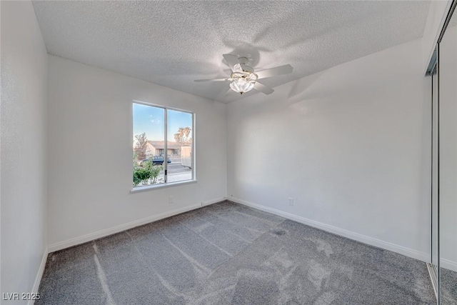 carpeted empty room featuring a ceiling fan, a textured ceiling, and baseboards