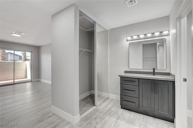 bathroom with visible vents, vanity, and wood finished floors