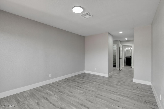 unfurnished room featuring recessed lighting, light wood-type flooring, visible vents, and baseboards