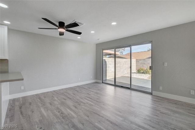 spare room with light wood-style floors, recessed lighting, visible vents, and baseboards