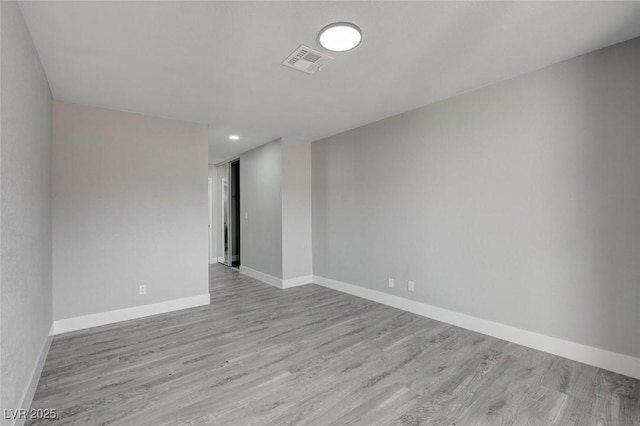 unfurnished room with light wood-style floors, visible vents, and baseboards