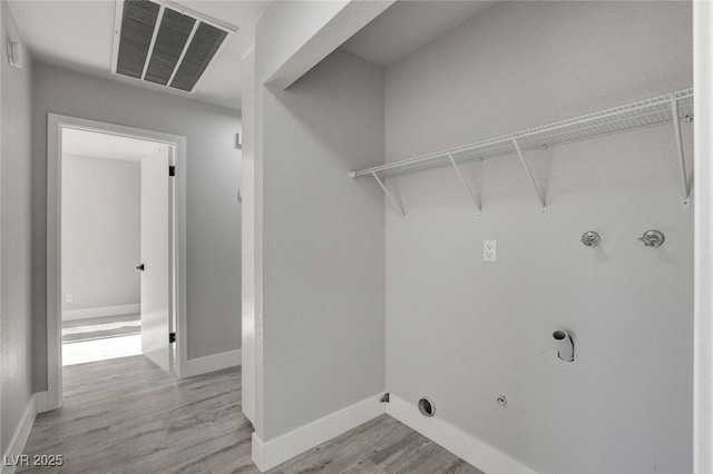 washroom with laundry area, light wood finished floors, baseboards, visible vents, and gas dryer hookup