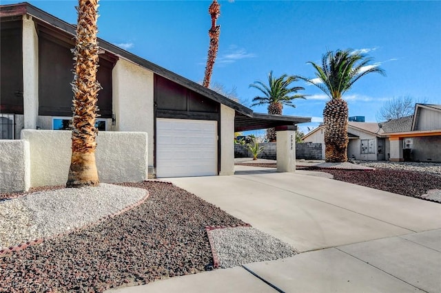 view of home's exterior with an attached garage, concrete driveway, and stucco siding