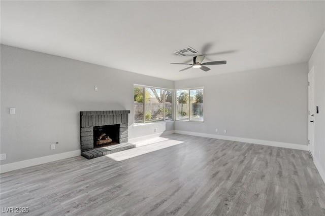 unfurnished living room featuring baseboards, visible vents, ceiling fan, light wood-style floors, and a fireplace