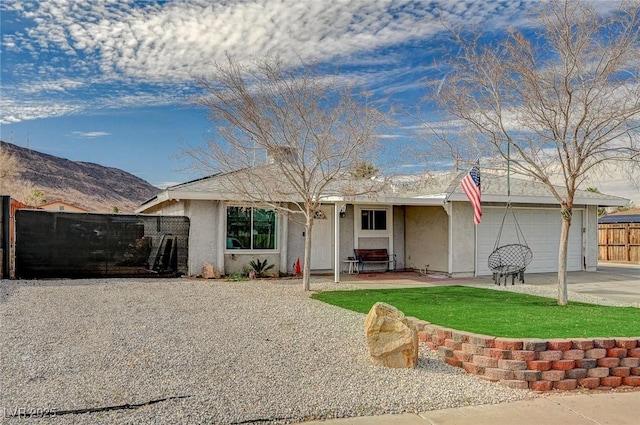 single story home featuring a garage, a hot tub, concrete driveway, fence, and stucco siding