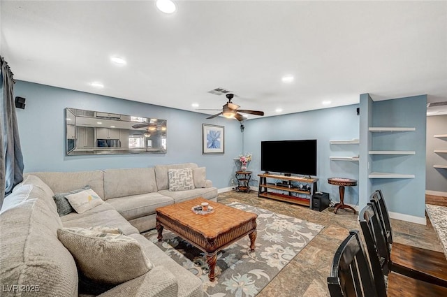 living room with baseboards, stone finish floor, visible vents, and recessed lighting