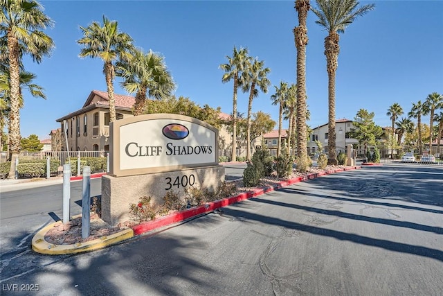 view of street featuring a residential view, a gated entry, and curbs