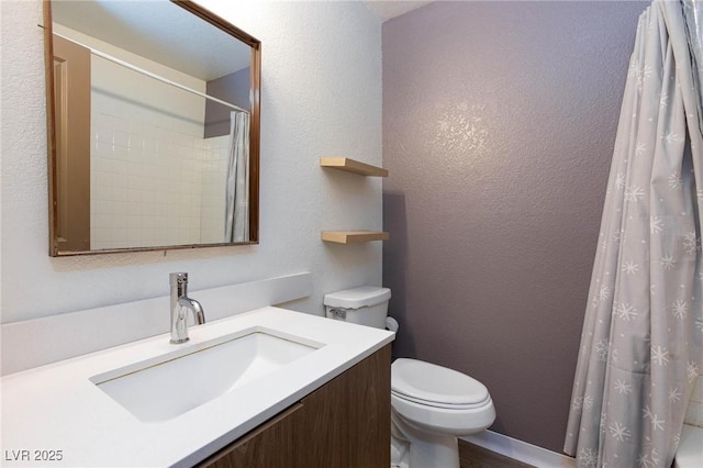 full bath featuring toilet, a textured wall, and vanity