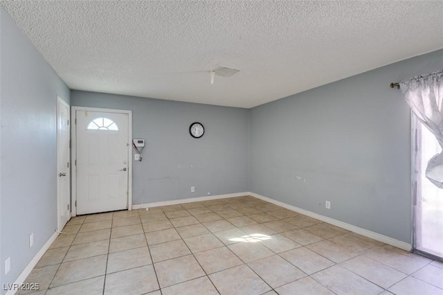 entrance foyer featuring baseboards, light tile patterned floors, and a healthy amount of sunlight