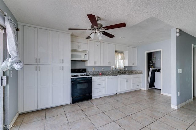 kitchen featuring light stone counters, light tile patterned floors, white cabinets, a sink, and white appliances