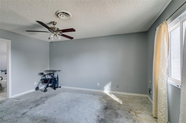 miscellaneous room with visible vents, a ceiling fan, light carpet, a textured ceiling, and baseboards