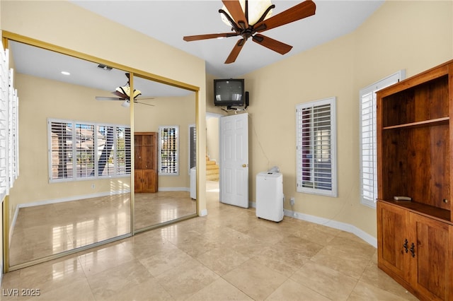 spare room featuring visible vents, a ceiling fan, and baseboards