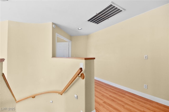 hallway with recessed lighting, visible vents, an upstairs landing, wood finished floors, and baseboards