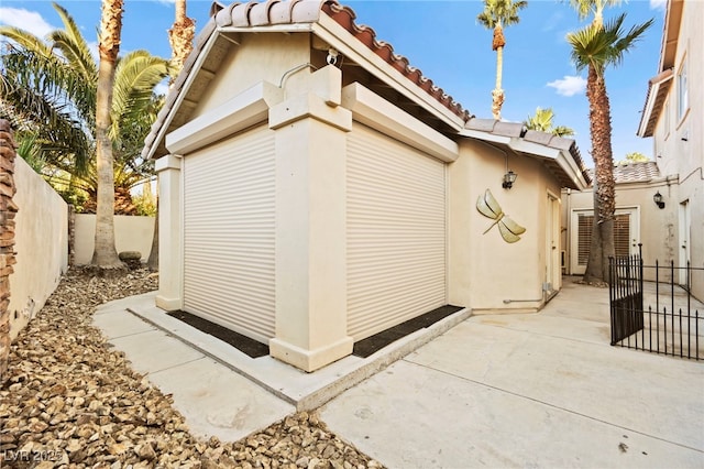 view of home's exterior featuring a patio area, a fenced backyard, a tile roof, and stucco siding