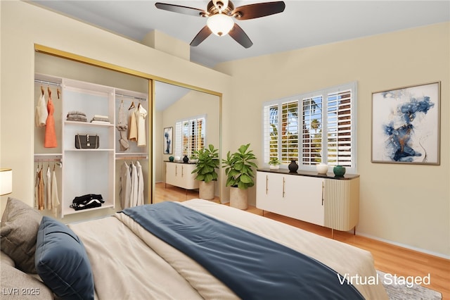 bedroom with a ceiling fan, lofted ceiling, a closet, and light wood finished floors