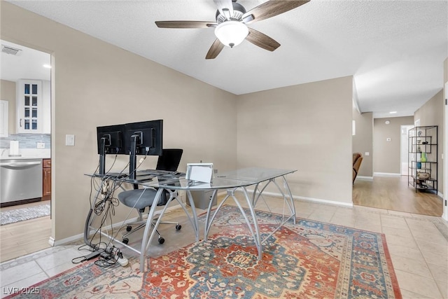 home office featuring light tile patterned floors, a textured ceiling, visible vents, and baseboards