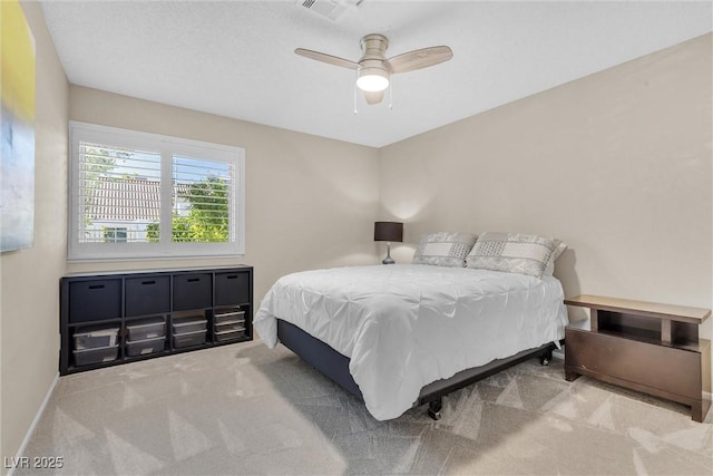 carpeted bedroom with baseboards, visible vents, and a ceiling fan