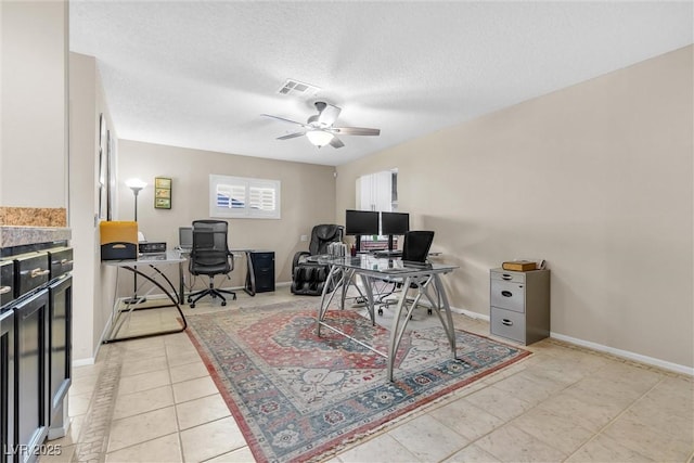 home office with baseboards, ceiling fan, visible vents, and a textured ceiling