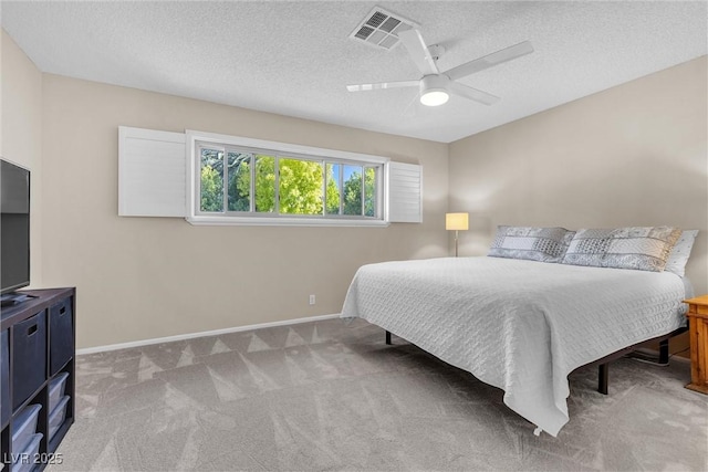 bedroom featuring visible vents, light carpet, baseboards, and a textured ceiling