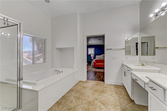 ensuite bathroom featuring ensuite bathroom, tile patterned flooring, a garden tub, vanity, and baseboards