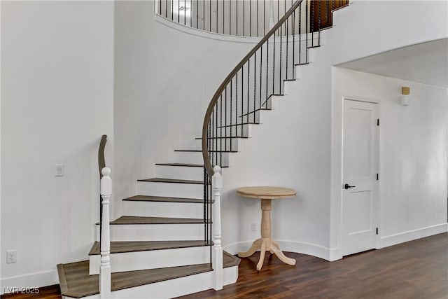 staircase with baseboards and wood finished floors