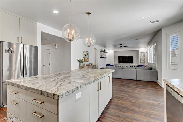 kitchen featuring decorative light fixtures, visible vents, appliances with stainless steel finishes, open floor plan, and white cabinetry