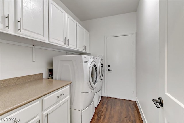 laundry room with cabinet space, washing machine and dryer, and dark wood-style flooring