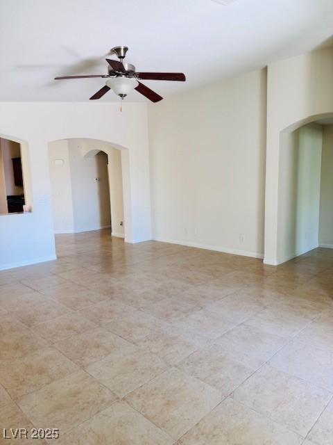 4562 White Cap Mill St, Las Vegas, NV 89147 - empty room with arched walkways, a ceiling fan, light tile patterned floors, and baseboards