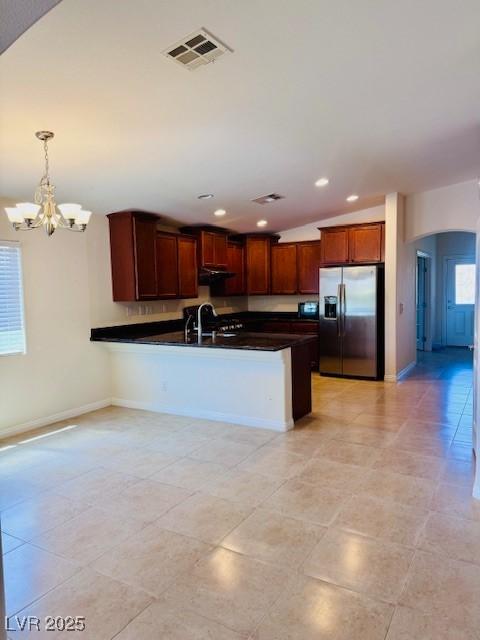4562 White Cap Mill St, Las Vegas, NV 89147 - kitchen featuring stainless steel fridge, dark countertops, arched walkways, a peninsula, and a chandelier