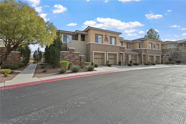 view of front facade with a residential view, driveway, an attached garage, and stucco siding