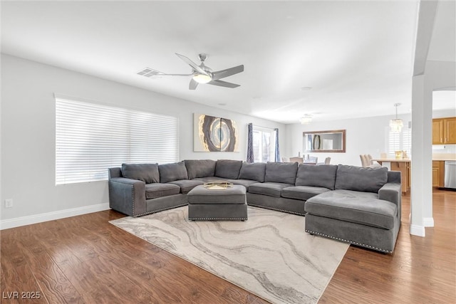 living area with a ceiling fan, baseboards, visible vents, and dark wood-style flooring