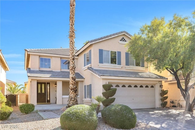 traditional-style home featuring a tile roof, driveway, an attached garage, and stucco siding