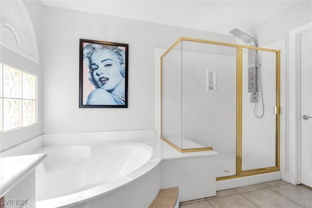 bathroom with a garden tub, a shower stall, and tile patterned floors