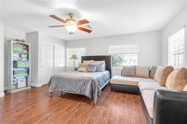 bedroom with multiple windows, dark wood finished floors, and visible vents