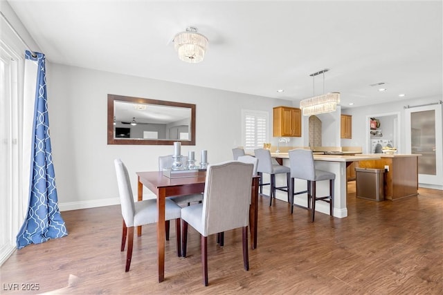 dining area with dark wood-type flooring, recessed lighting, and baseboards