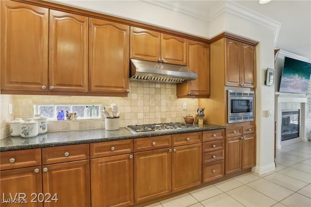 kitchen with appliances with stainless steel finishes, brown cabinets, and under cabinet range hood