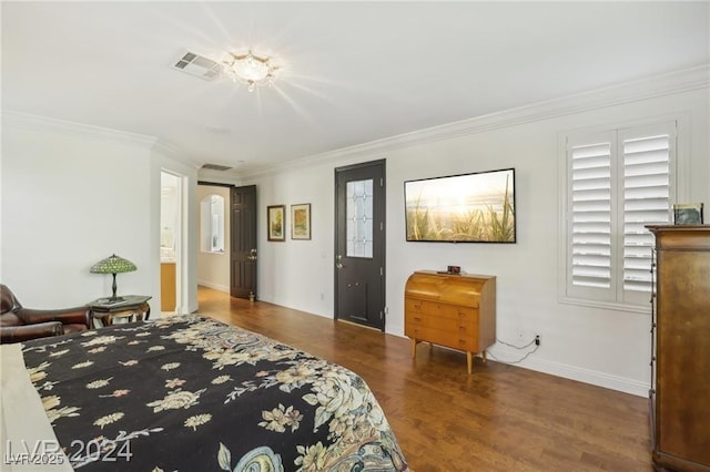 bedroom with ornamental molding, wood finished floors, visible vents, and baseboards