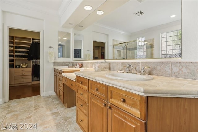 full bathroom with a spacious closet, ornamental molding, a sink, and visible vents