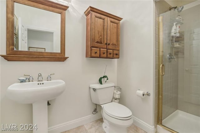 bathroom with toilet, a shower stall, baseboards, and a sink