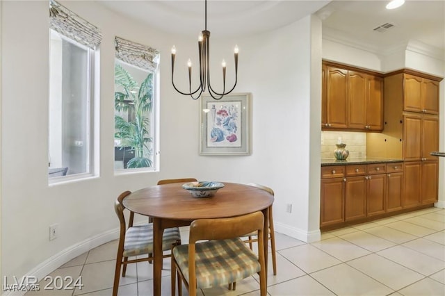 dining area featuring light tile patterned floors, a chandelier, visible vents, baseboards, and ornamental molding