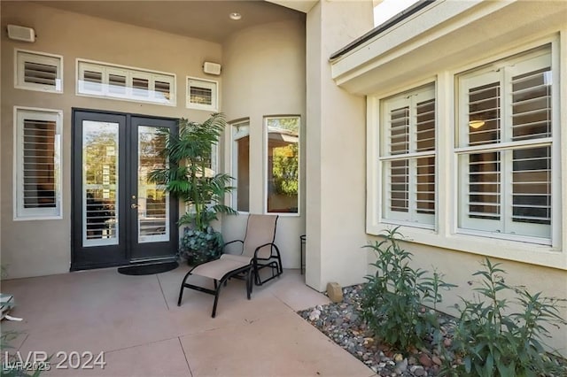 view of exterior entry with french doors and stucco siding
