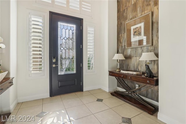 foyer with plenty of natural light, baseboards, and light tile patterned flooring