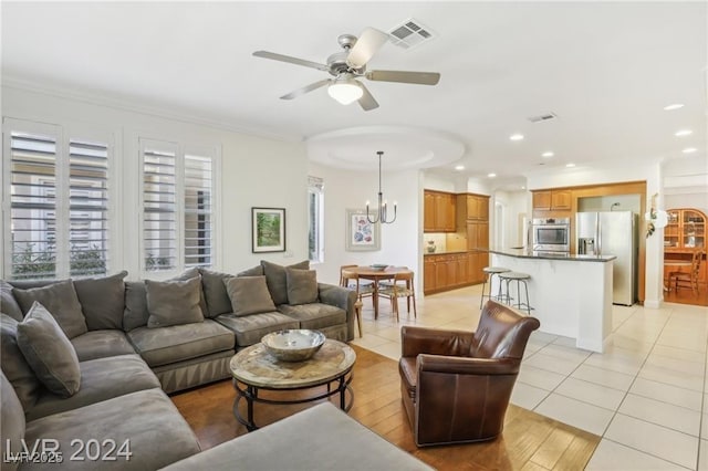 living room with light tile patterned floors, recessed lighting, visible vents, and ceiling fan with notable chandelier