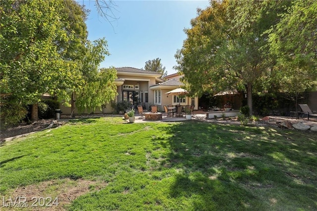 back of house featuring stucco siding, a patio, fence, and a lawn