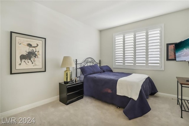 bedroom featuring light carpet and baseboards